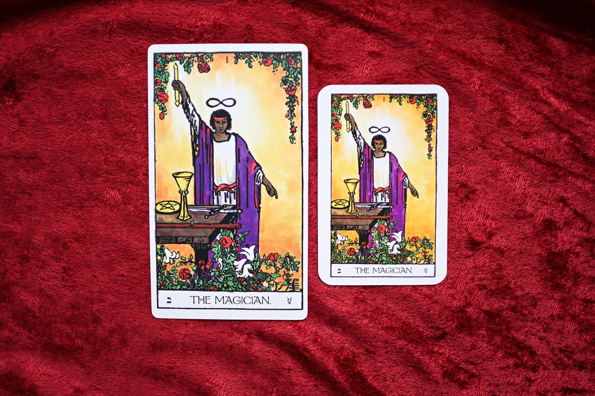 Two tarot cards titled 'The Magician' on a red fabric background