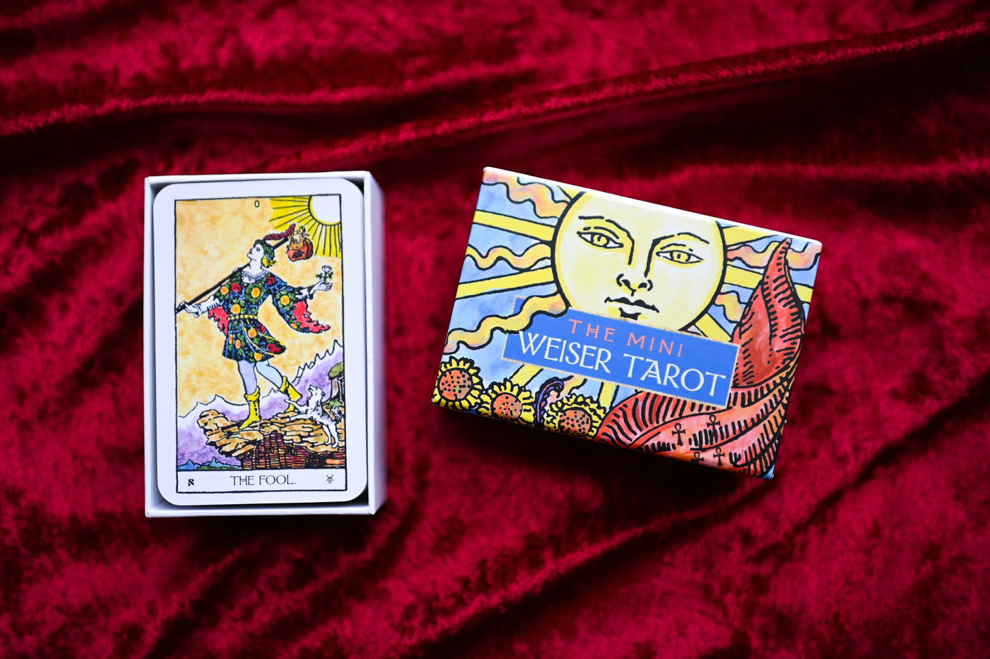 Mini Weiser Tarot box and card on a red fabric background